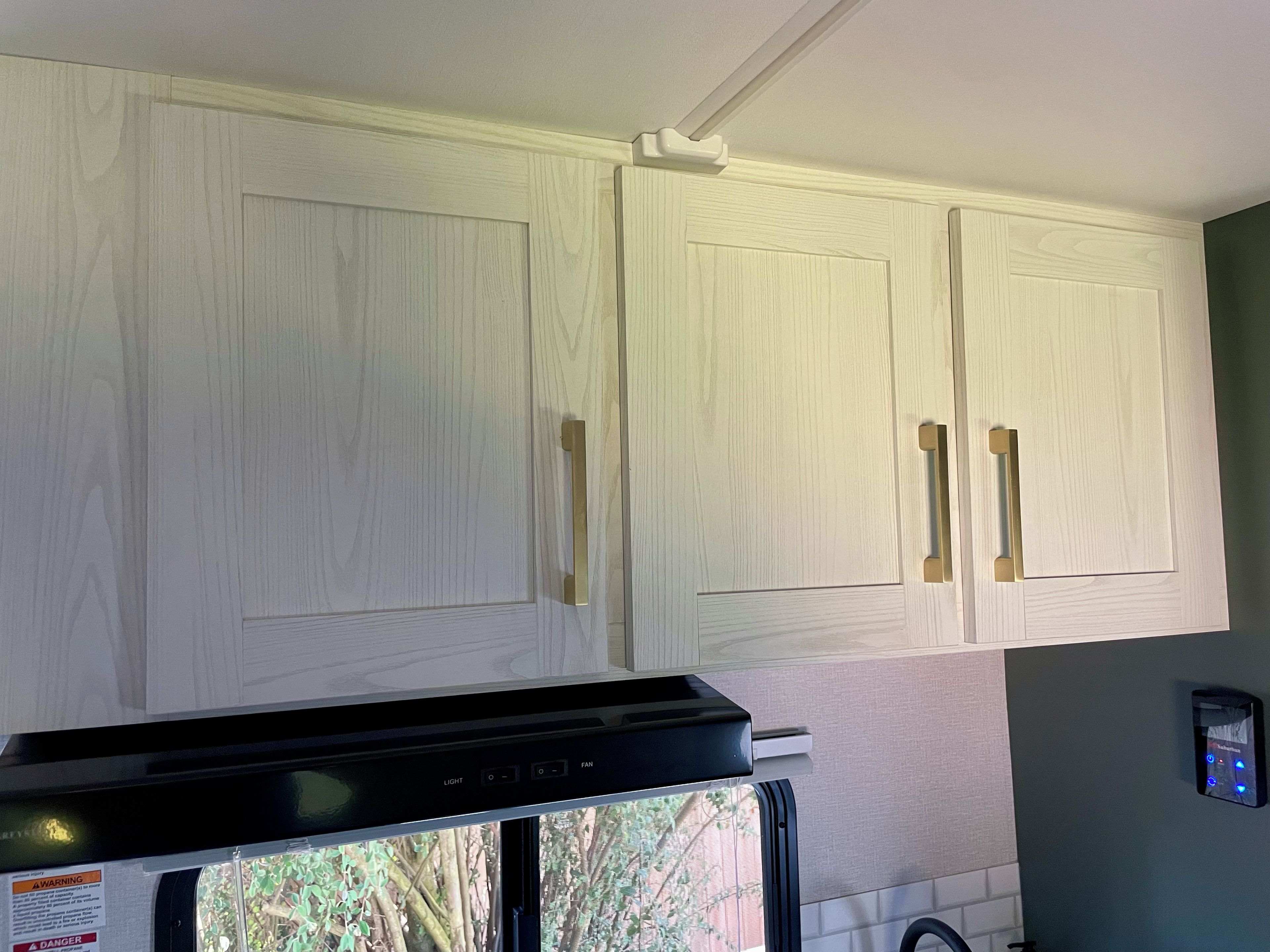 A kitchen with white cabinets, a black countertop, and a built-in stove.
