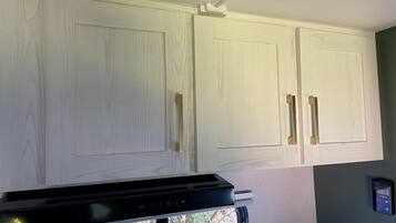 A kitchen with white cabinets, a black countertop, and a built-in stove.