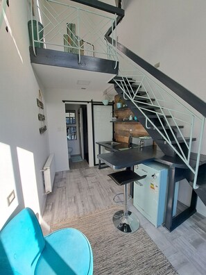 A modern interior with a staircase, a kitchen area, and a dining space. - Okeyloft 3 Coyhaique (Coyhaique)