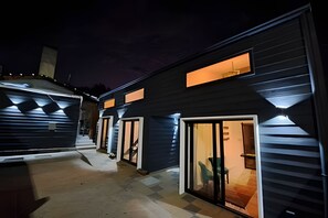 A modern building with multiple entry points, including doors and windows, and a covered outdoor area. - Okeyloft 3 Coyhaique (Coyhaique)