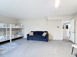 Una habitación con literas, un sofá y una mesita.