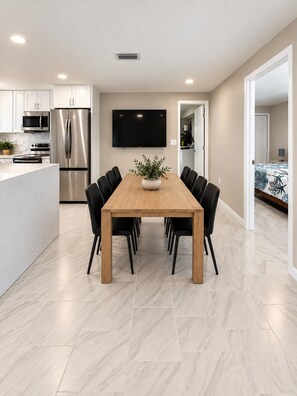 A modern kitchen with a built-in oven, microwave, and stainless steel refrigerator.