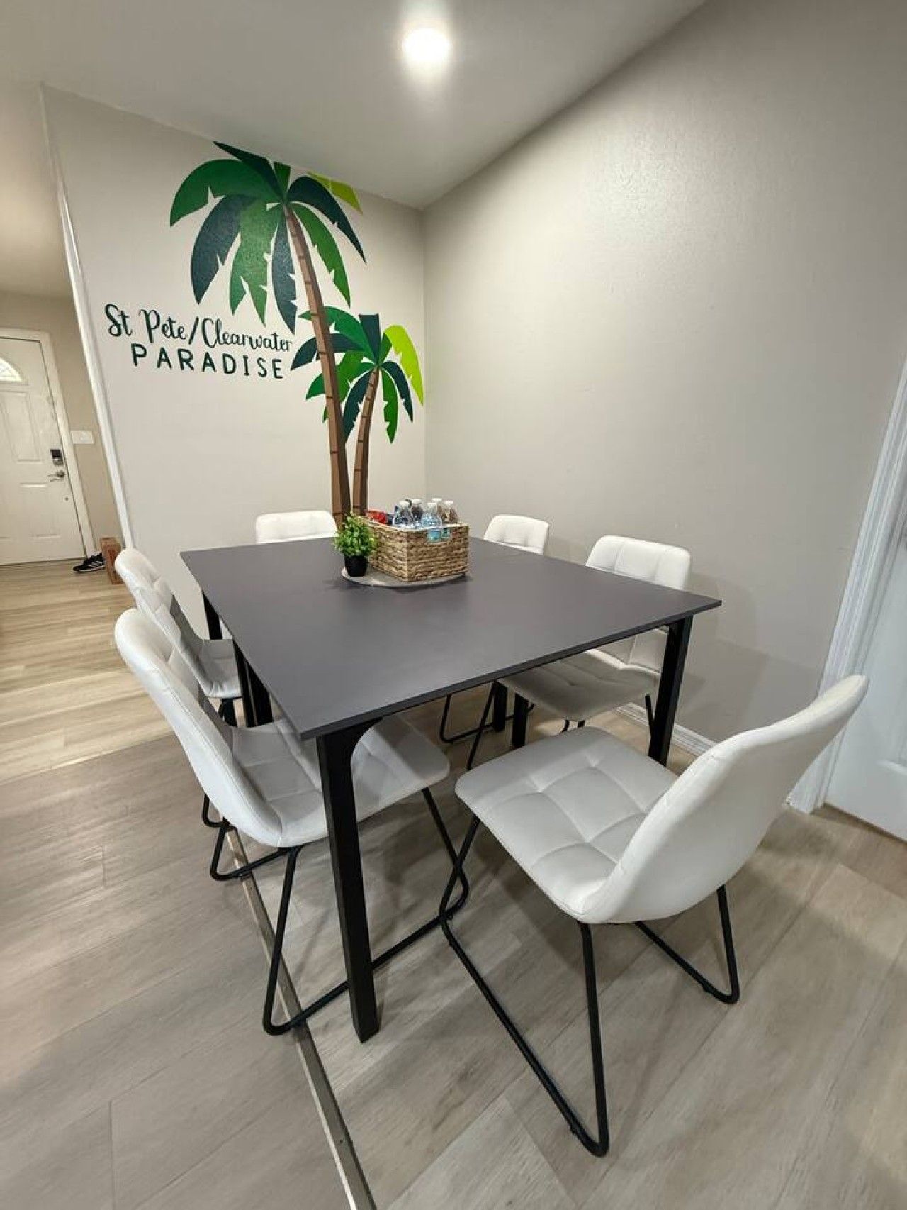 Un espace repas comprenant une table, des chaises et un élément décoratif mural.