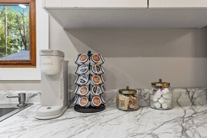 A kitchen with a coffee maker, a tea infuser, and two glass jars with lids. - Sleeps 12, Hot Tub, Game room, Sauna, Theater (Logan)