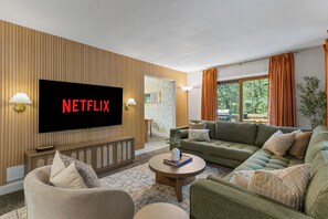 A living room with a flat-screen TV, a sofa, a coffee table, and a fireplace. - Sleeps 12, Hot Tub, Game room, Sauna, Theater (Logan)
