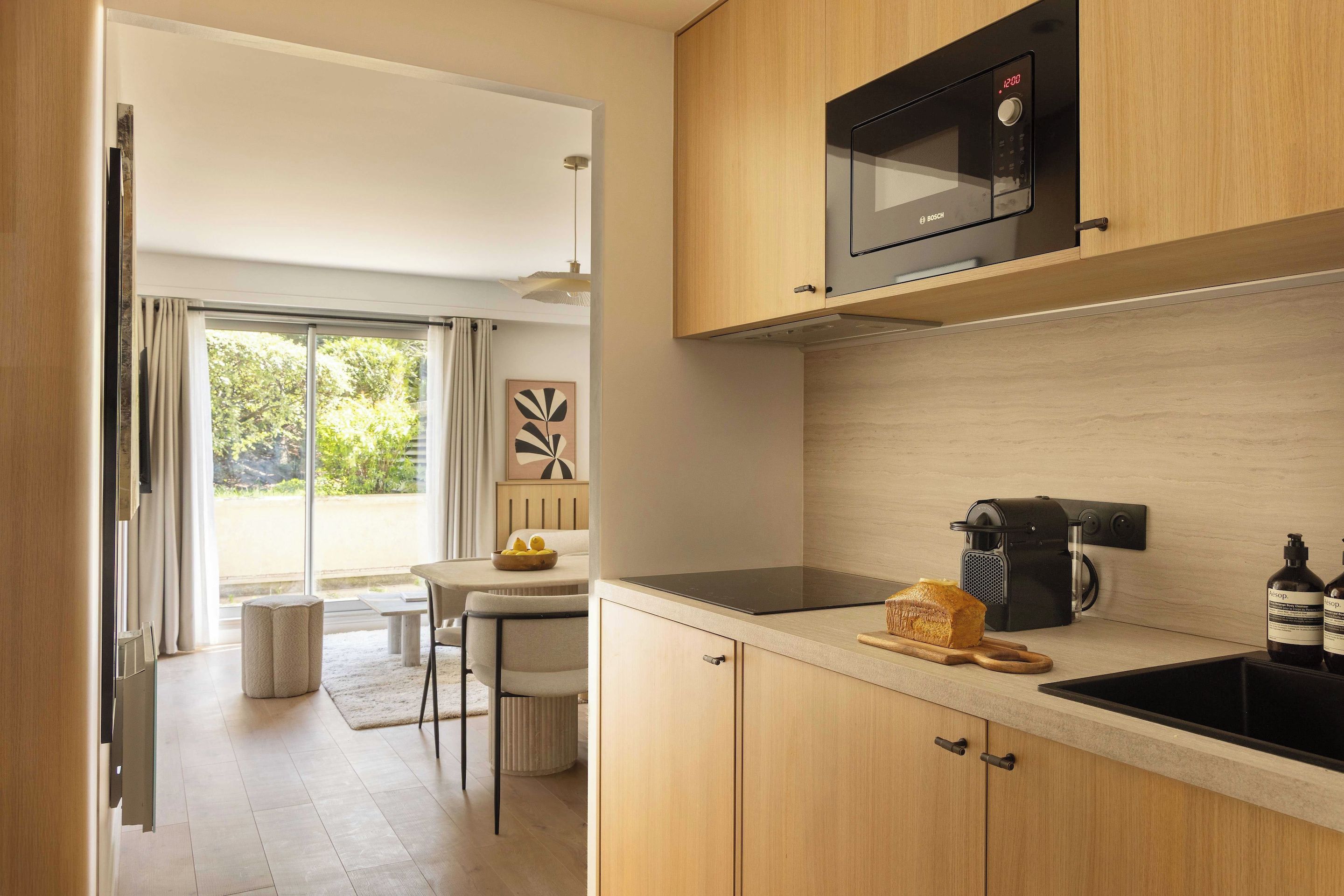 Una cocina moderna con un microondas Bosch, hogaza de pan y una cafetera.
