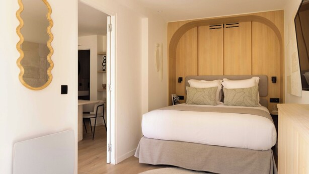 Una camera da letto con un letto grande, una testiera in legno, una scrivania e una sedia.