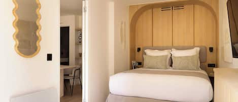 Une chambre à coucher avec un grand lit, une tête de lit en bois, un bureau et une chaise.