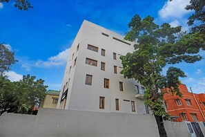 Un edificio de varios pisos con fachada plana, ventanas rectangulares y una entrada visible.