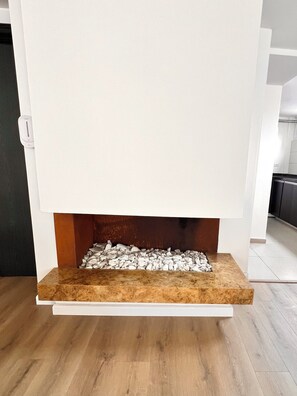A modern fireplace with a white mantel and a wooden shelf below. - Apartamento Premium/a pasos de la Zona t /Parque 93/100mt (Bogotá, D.C.)