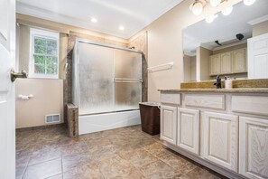 A bathroom with a shower, vanity, and a window. - Goguac Lake House|Sleeps6|Private Dock|Boat Launch (Battle Creek)