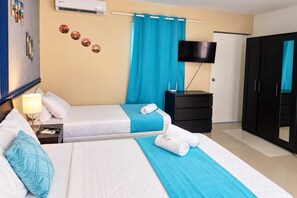 A hotel room with two beds, a TV, a wardrobe, and a mirror. - Sol Caribe Bar on the Beach (Punta Cana)