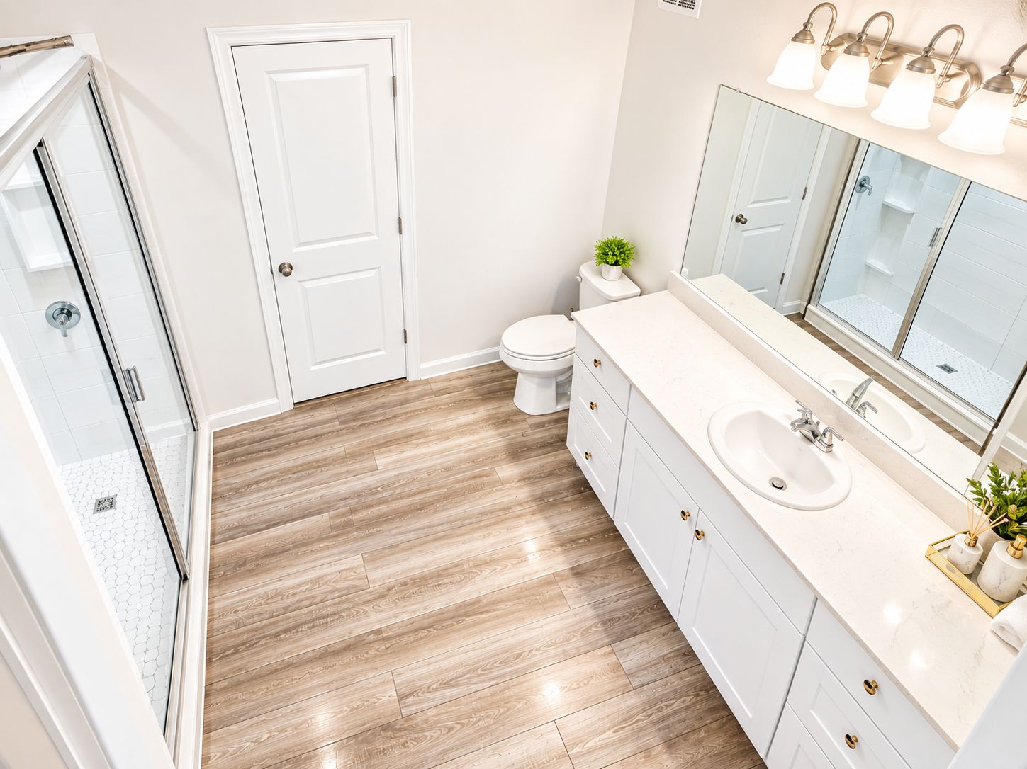 A modern bathroom with a glass shower enclosure, a white toilet, a vanity with a large mirror, and a sink.