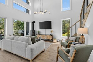 Ein geräumiges Wohnzimmer mit einer großen Couch, einem Holztisch und einem Kamin.