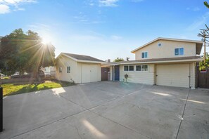 Ein zweigeschossiges Wohnhaus mit Garage, überdachter Auffahrt und kleinem Vorgarten.