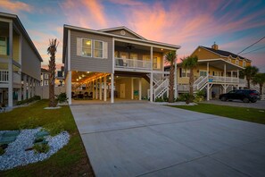 A two-story residential building with a covered patio, a carport, and a visible address number.