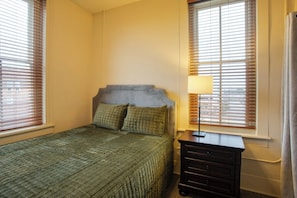 A bedroom with a bed, a nightstand, and a window with blinds. - Downtown Florence Retreat | Walkable Historic Stay (Florence)