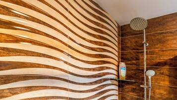 Ducha con diseño moderno, que presenta una pared curva y un cabezal de ducha manual.