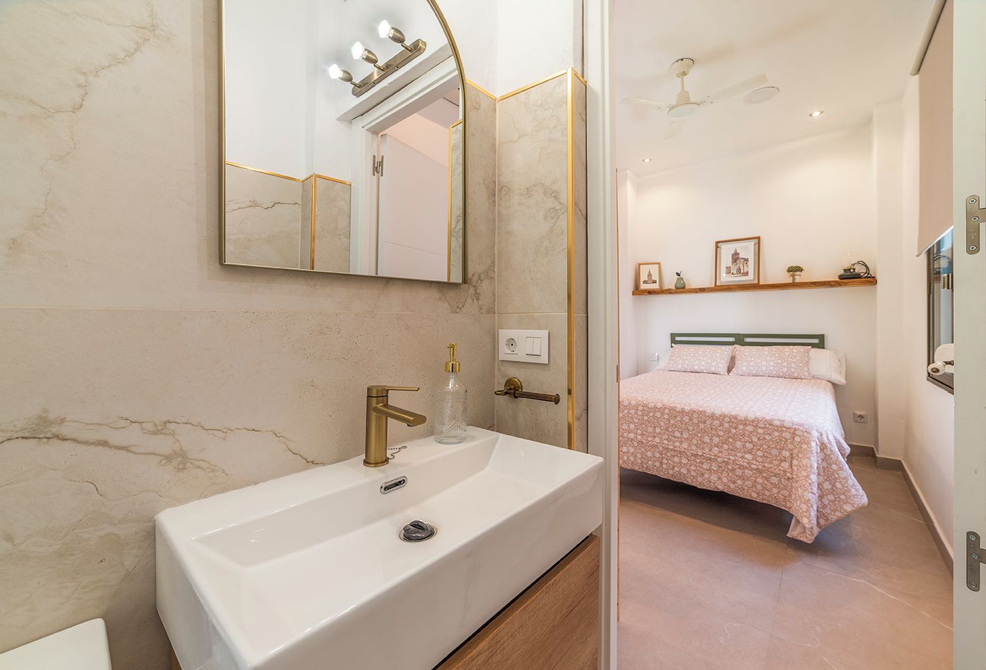 A modern bathroom with a large mirror, a white sink, and a shower area.