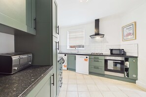 A modern kitchen with a built-in toaster, a microwave, an oven, and a dishwasher. - South Kirkby Home | Sleeps 6 | Parking (South Kirkby)