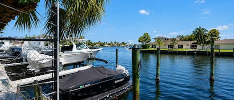 A marina with boats docked, a chain-link fence, and a clear blue sky.