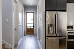 A kitchen with a stainless steel refrigerator, a built-in oven, and a water dispenser. - The Eastside Darling - Modern 4BR w/ Fenced Yard, East Nashville 30+ Day Stay (Nashville)