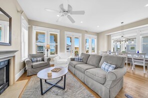 A spacious living room with a grey sofa, a round coffee table, and a ceiling fan. - 🌴C'est la Vue | Gulf Views | 3 Pools | Walk to Beach | 3 Levels🌴 (Destin)