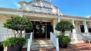 A restaurant with a white facade, a sign reading 'Tommy Bahama Restaurant | Bar | Store', and a covered entrance with steps. - 🏖️Coral Cove 83A | Community Pools + Tennis Courts | Close to Beach🌴 (Miramar Beach)
