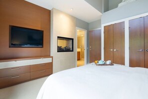 A bedroom with a large bed, a TV mounted on the wall, a wardrobe, and a framed picture on the wall. - 4BR Ski Chalet, 2472 Sq Ft, w/ Pvt HotTub & Garage (Whistler)