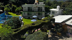 A two-story building with a swimming pool and umbrellas in the courtyard. - Vrbo Property (Tepoztlan)