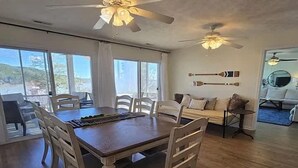 Ein Essbereich mit Holztisch und -stühlen, einer Couch und einem Deckenventilator.