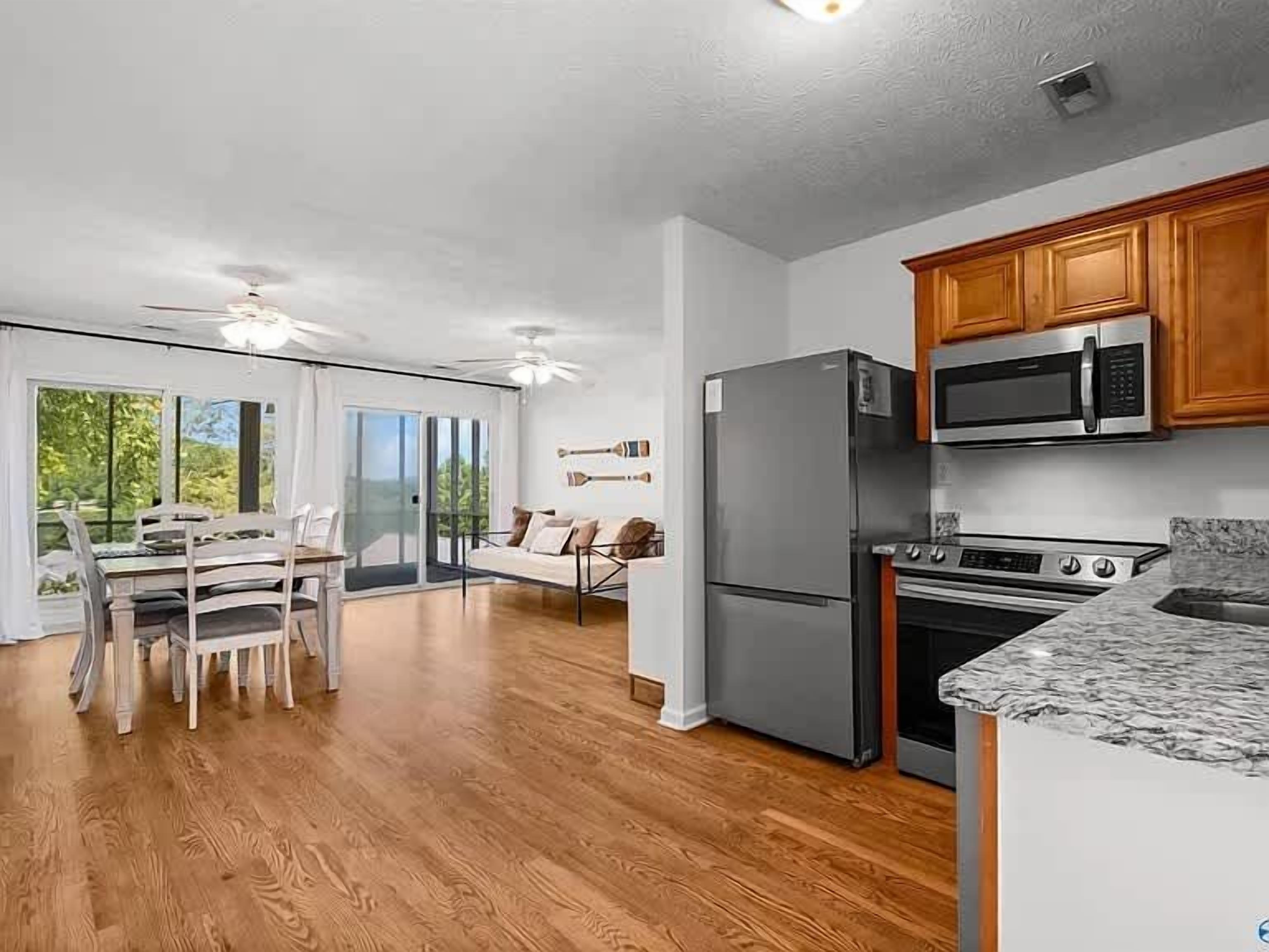 A modern kitchen with a refrigerator, microwave, and stove.
