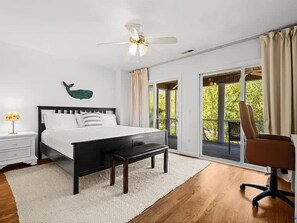 Una camera da letto con un letto, un comodino, una sedia e vista sull'esterno.