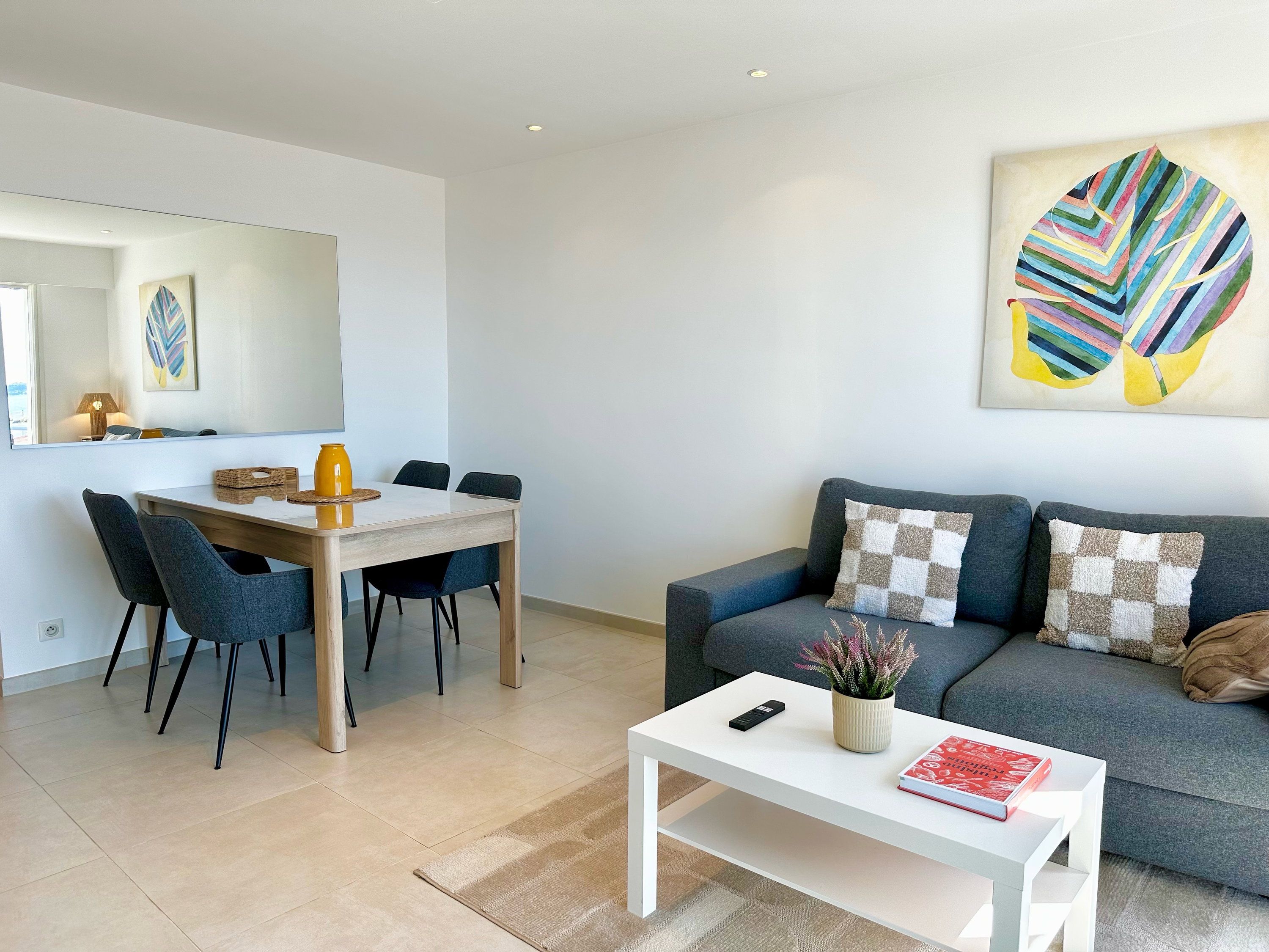 A modern living room with a dining area, a sofa, and a coffee table.