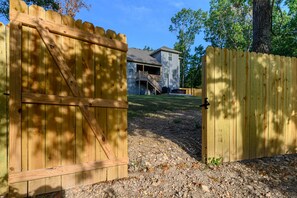 A wooden gate leading to a house with a covered porch and a staircase. - Trailfront Ride & Reel - Upscale Retreat 4bd/2.5ba Sleeps 10 - HOT TUB! (Bella Vista)