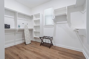 A walk-in closet with open shelving, a hanging rack, and a window with blinds. - Trailfront Ride & Reel - Upscale Retreat 4bd/2.5ba Sleeps 10 - HOT TUB! (Bella Vista)