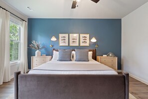A bedroom with a bed, two bedside tables, a window with curtains, and wall-mounted lights. - Trailfront Ride & Reel - Upscale Retreat 4bd/2.5ba Sleeps 10 - HOT TUB! (Bella Vista)