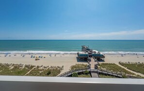 A beach with a pier, a boardwalk, and a view of the ocean. - Oceanfront Serenity at Yachtsman! S800 (Myrtle Beach)