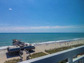 A beach with a pier and a lifeguard tower. - Oceanfront Serenity at Yachtsman! S800 (Myrtle Beach)
