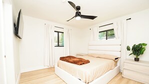A bedroom with a bed, a ceiling fan, a window, and a plant. - Luxury 3BR Retreat - Modern Comfort in Fort Lauderdale (Fort Lauderdale)
