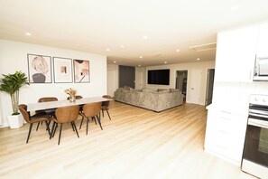 Eine moderne Küche mit Einbauofen und Essbereich mit Holztisch und Stühlen.