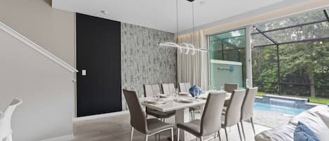 Un comedor moderno con vista a la piscina, una escalera y un diseño minimalista.