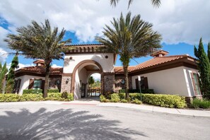 A building with a central archway, surrounded by palm trees and a clear sky. - 5BD Family Home with Pool BBQ and Themed Rooms (Davenport)