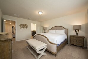 A bedroom with a bed, bedside tables, a bench, and a dresser. - 5BD Family Home with Pool BBQ and Themed Rooms (Davenport)