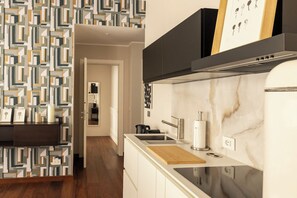 A modern kitchen with a marble countertop, a built-in oven, and a black range hood. - Icona Lagrange | Egyptian Museum & Piazza SanCarlo (Turin)