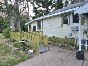 A single-story house with a front porch, a small outdoor table, and a pathway leading to the entrance. - Wabana Sage House Grand Rapids, MN by the forest (Grand Rapids)