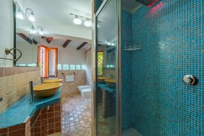 A bathroom with a large mirror, two sinks, a shower, and a tiled floor. - Villa Baja (Baja Sardinia)