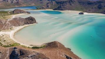 Un paysage côtier caractérisé par une vaste étendue d’eau, des plages de sable et des affleurements rocheux.