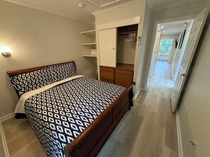Une chambre à coucher comprenant un lit, une armoire et un placard intégré.