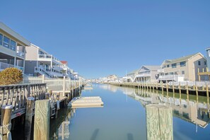 A canal with waterfront properties, wooden docks, and a clear sky. - Cozy 2-bedroom house on beautiful lagoon (Stafford Township)